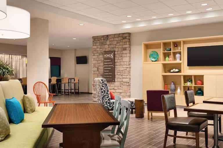 Contemporary hotel lobby featuring fireplace, modern seating, and wooden shelving unit