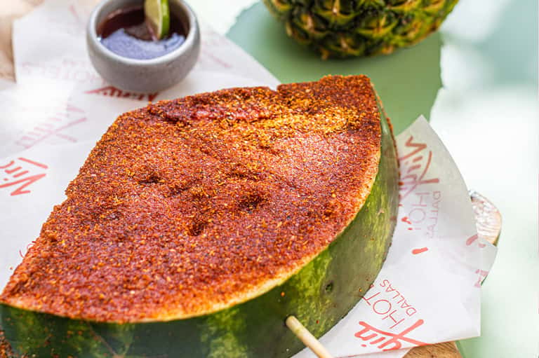 Spicy mango fruit with red chili powder seasoning on white wrapper
