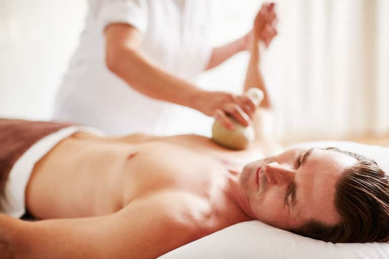 Man receiving relaxing spa massage treatment at resort wellness center