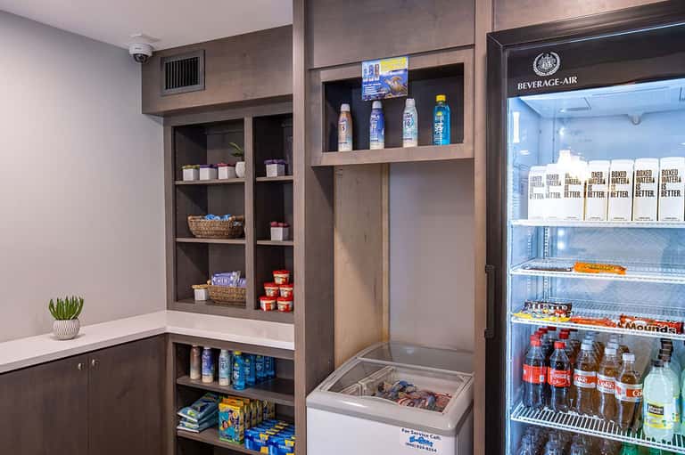 Convenience shop stocked with sunscreen, snacks, beverages, and boxed water in organized shelving