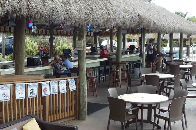 Beachfront tiki bar with thatch roof and casual seating area