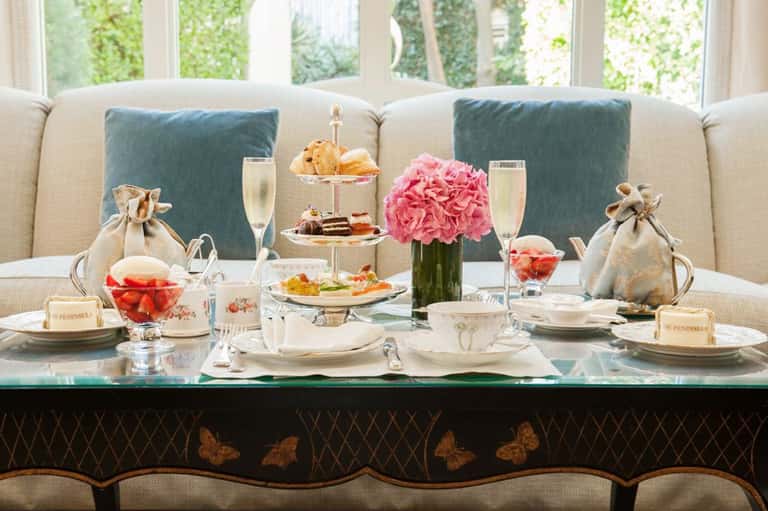 Elegant brunch setup with champagne, pastries, flowers, and fine dining service