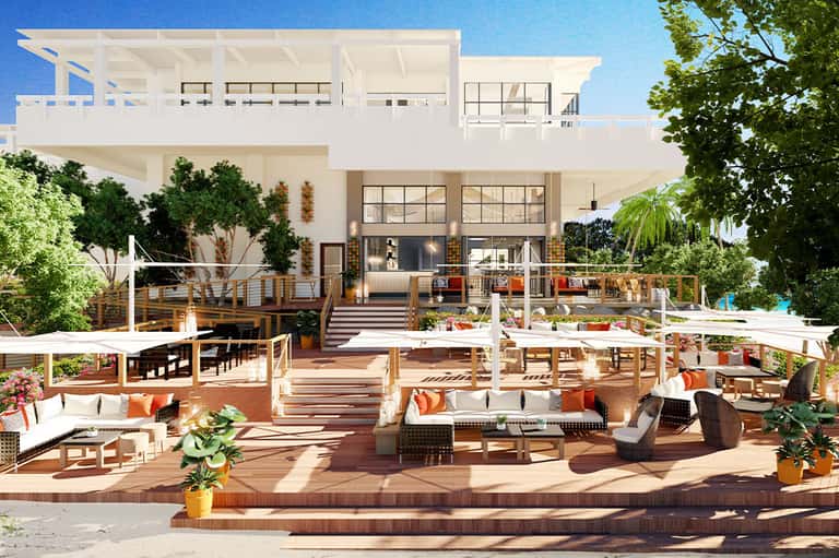 Modern luxury home exterior with multi-level deck, furniture, and landscaping