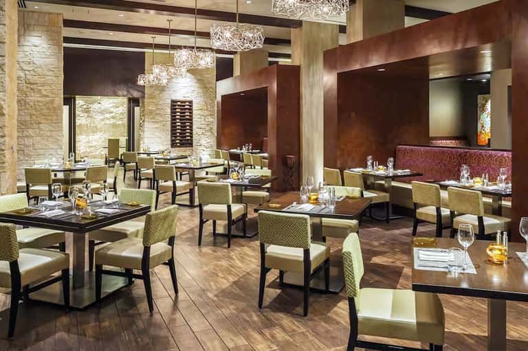Fine dining restaurant with stone walls, elegant seating, and crystal chandeliers