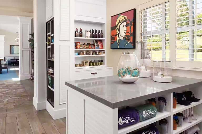 Modern hotel gift shop interior with white shelving, merchandise display, and pop art wall decor