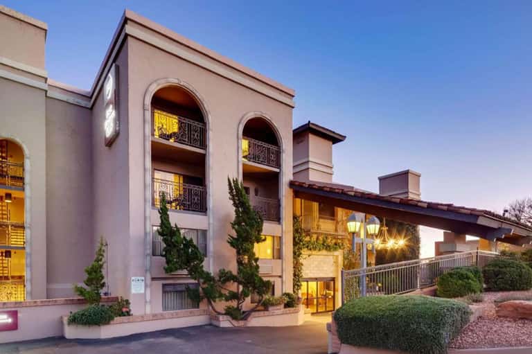 Contemporary resort building exterior with arched windows and warm evening illumination