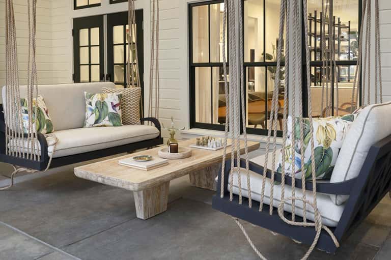 Rope swing seating area overlooking patio doors with neutral cushions and wooden table