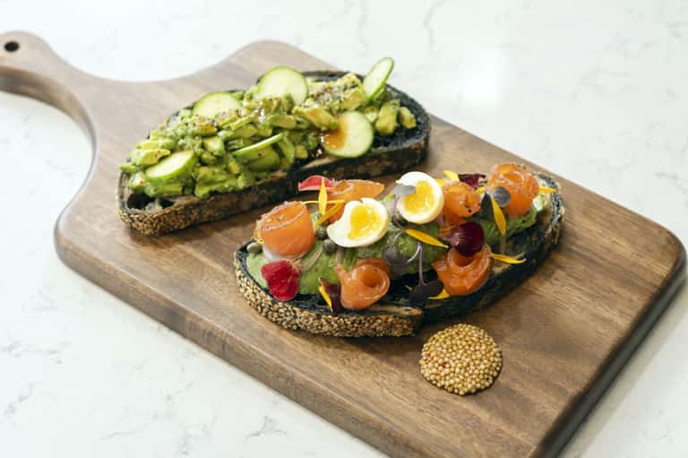 Gourmet open-faced sandwiches with avocado and smoked salmon on seeded bread