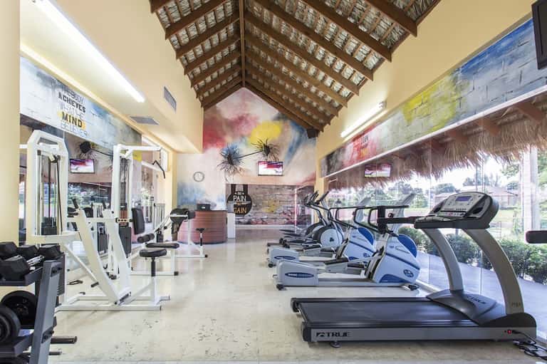Modern fitness center with treadmills, exercise equipment, and colorful inspirational wall art