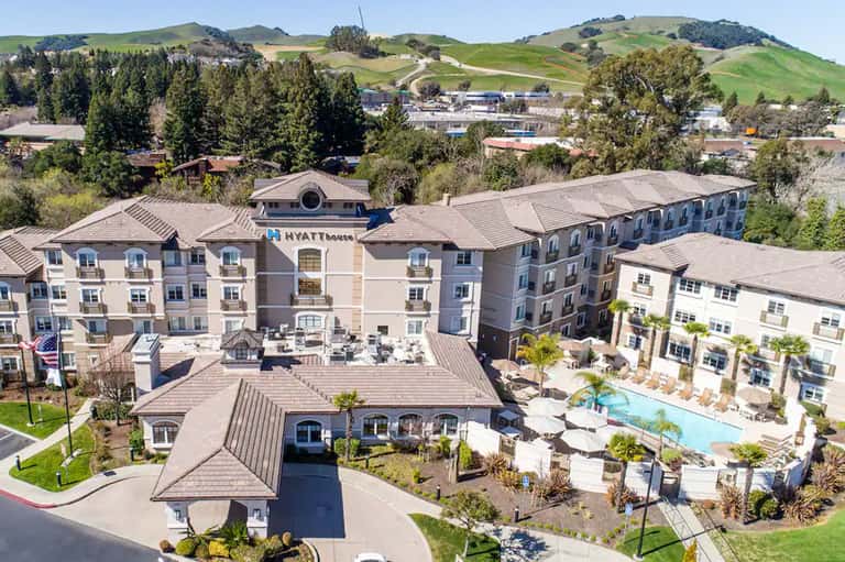Hillside Hyatt House hotel exterior with multi-story buildings and resort pool amenities