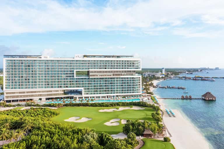 Beachfront resort with turquoise pool, golf course, and ocean waterfront views