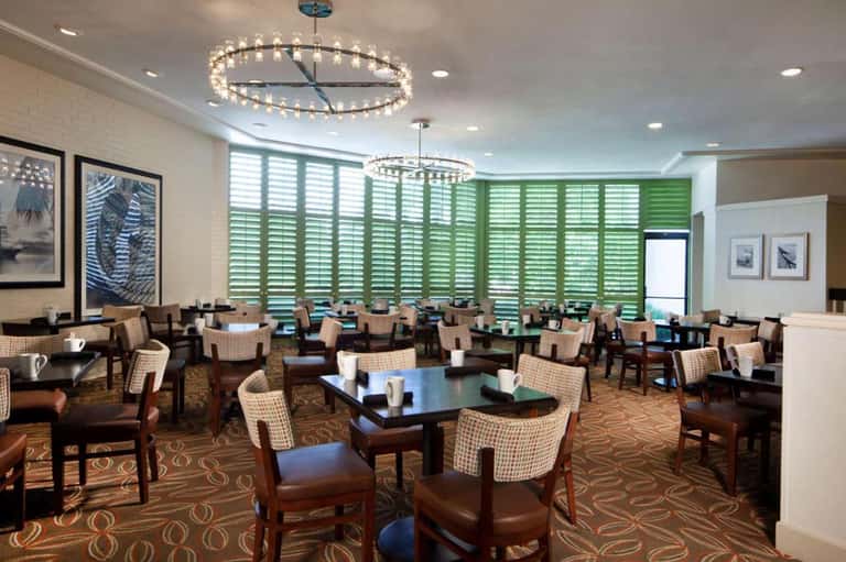 Modern lounge with decorative lighting, comfortable seating, and green shutters