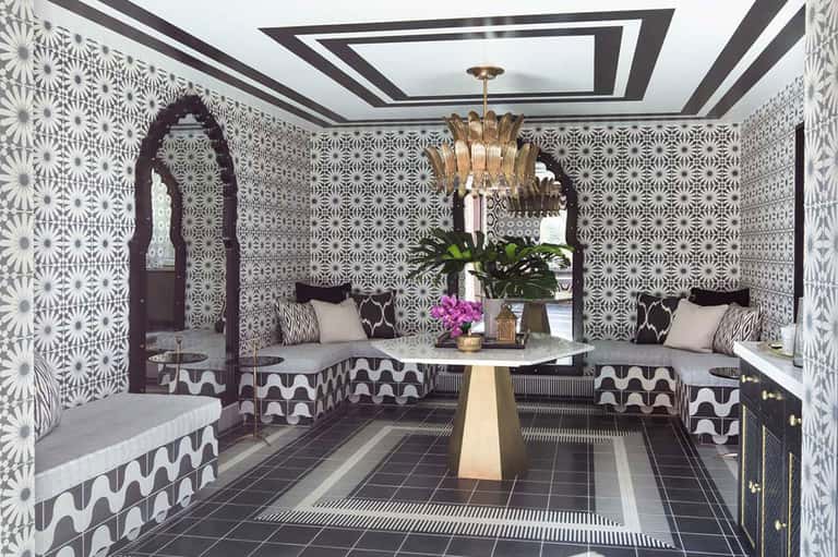 Ornate spa lounge with black and white geometric patterns, gold chandelier, and built-in seating