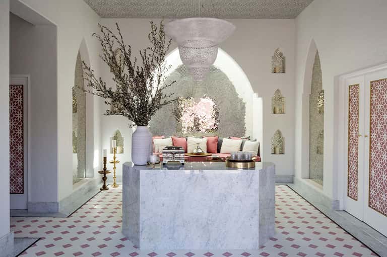 Elegant marble spa entrance with arched alcoves, flowers, and decorative geometric flooring