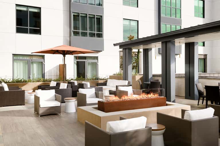 Modern patio with fireplace, comfortable seating, and contemporary architecture