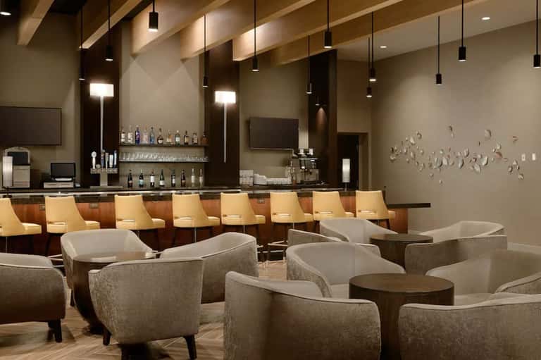 Upscale hotel lounge with bar seating, modern furniture, and ambient lighting