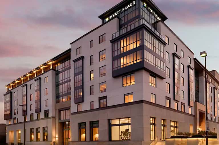 Modern Hyatt Place hotel exterior at dusk with illuminated windows and contemporary architecture