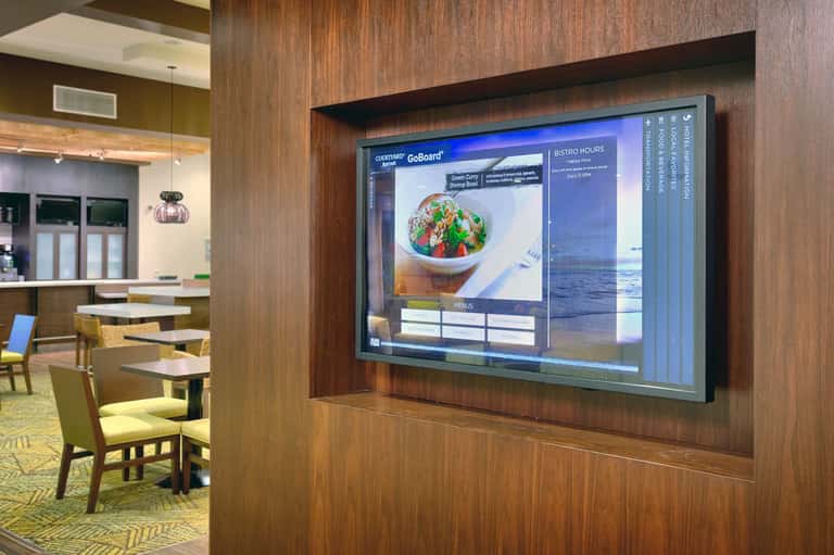 Digital menu board displaying food items in modern hotel bistro or restaurant area