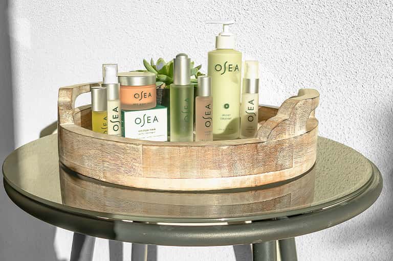 Display of OSEA skincare and wellness products arranged on wooden tray