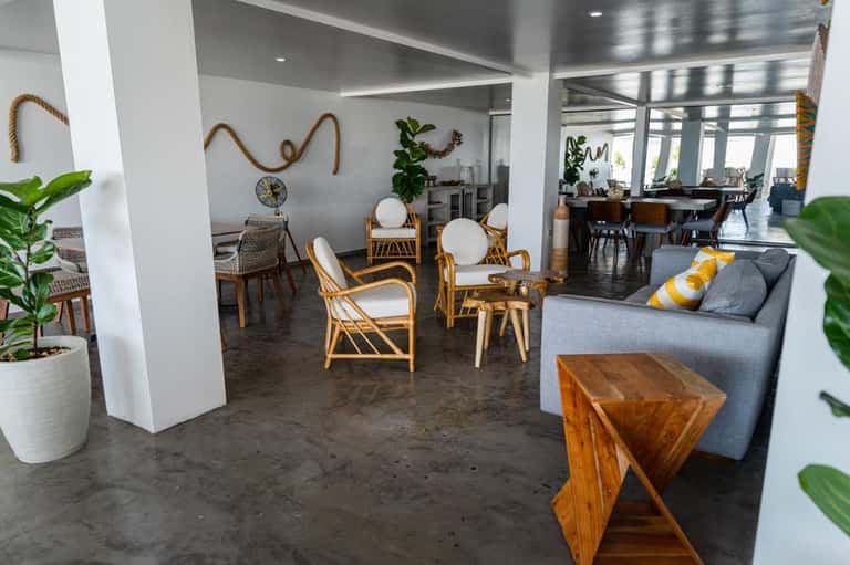 Modern resort lobby with rattan chairs, plants, and coastal decor