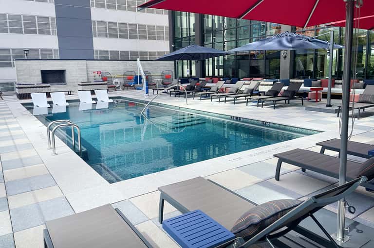 Contemporary urban pool with loungers under red and black umbrellas
