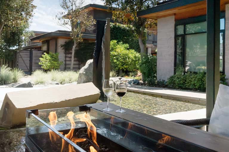 Modern courtyard with fire pit, wine glasses, contemporary architecture, and landscaping