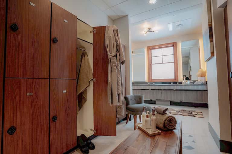 Luxurious spa bathroom with wooden vanity, soaking tub, and lounge seating area