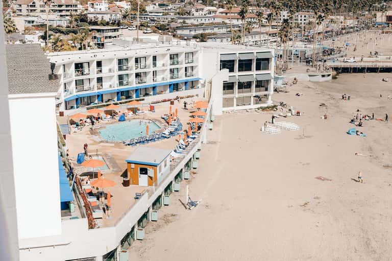 Beachfront hotel with orange and blue pool deck directly on sandy beach