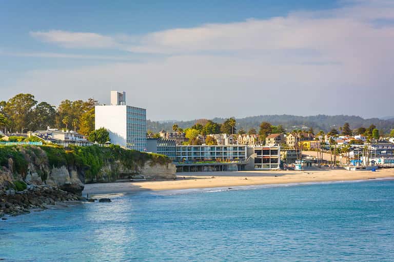 Beachfront hotel building on sandy coast with rocky cliffs and ocean view