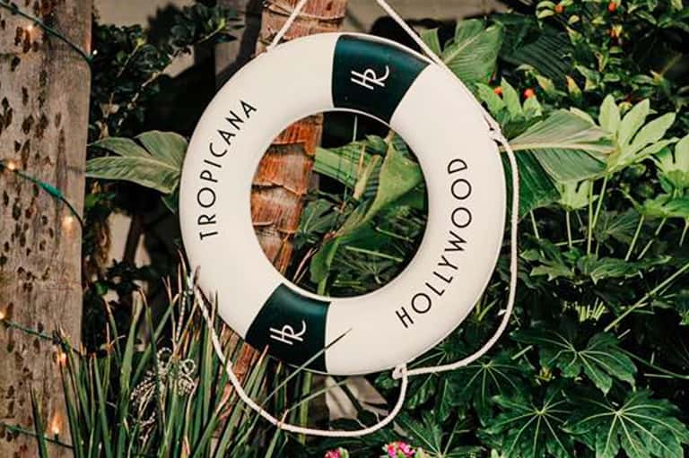Tropical Hollwood life buoy sign hanging in lush garden setting