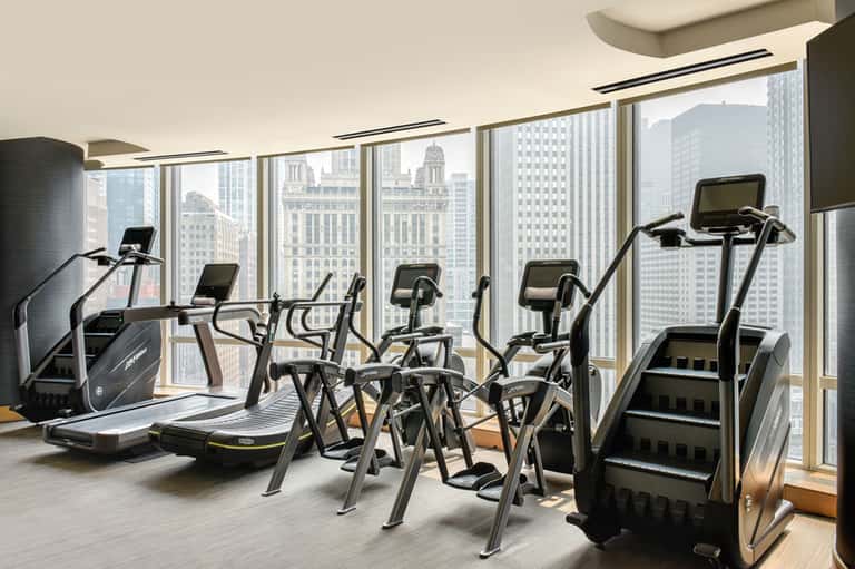 High-rise fitness center with exercise equipment and panoramic city skyline views