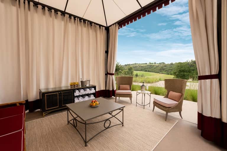 Luxury pavilion with cream curtains overlooking rolling green countryside landscape