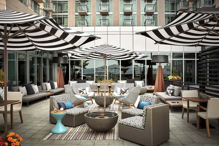 Upscale patio with black and white striped umbrellas, seating, and fire pit