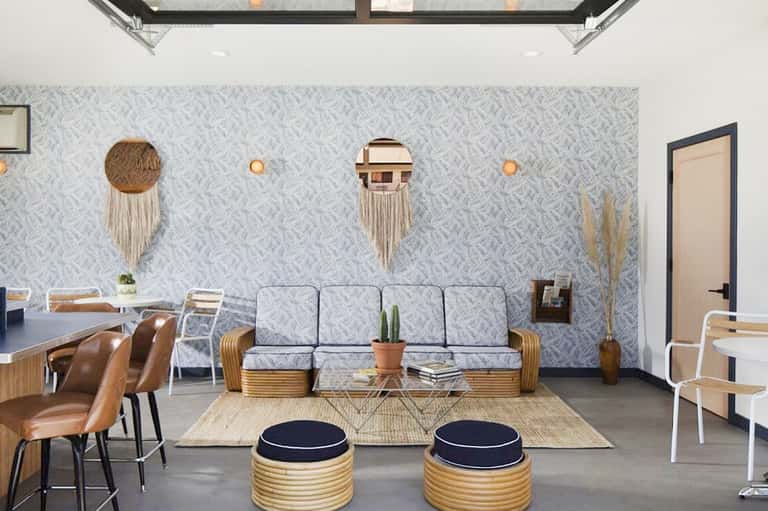 Contemporary resort lobby with patterned wallpaper, woven wall art, modern furniture, and skylight