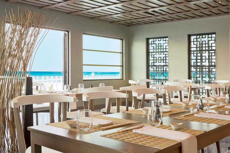 Modern beachfront restaurant dining room with ocean views and contemporary furnishings