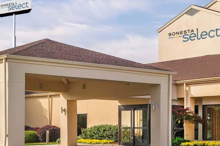 Sonesta Select hotel exterior with modern architecture, covered entrance, and manicured landscaping
