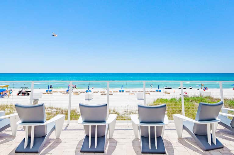 Beachfront lounge chairs with ocean view and clear blue sky