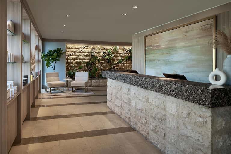 Modern hotel lobby with stone reception desk, wooden accents and contemporary furnishings