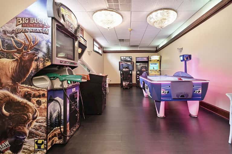 Game room with arcade games, air hockey table, and neon lighting