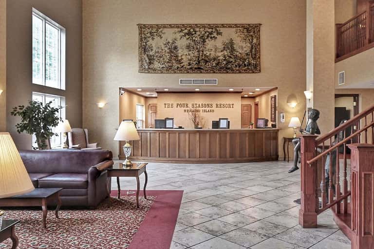 Four Seasons Resort lobby with reception desk, wooden railings, elegant furnishings and high ceilings