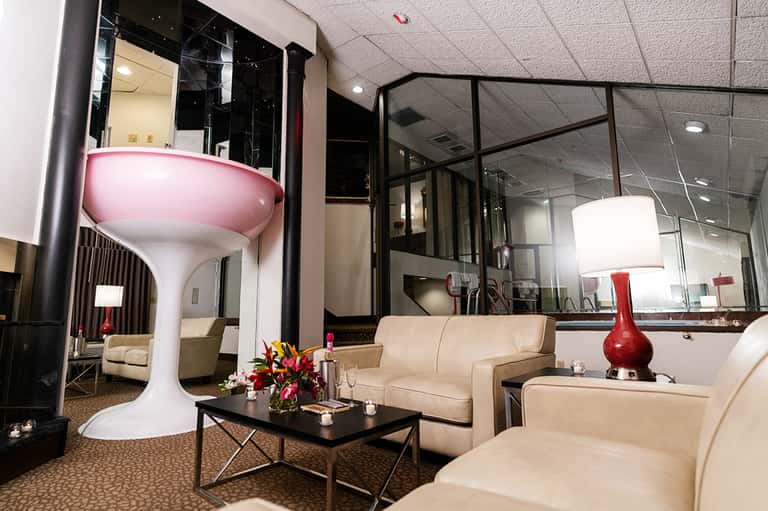 Modern hotel lounge with cream furniture, red accent lamp, and contemporary design
