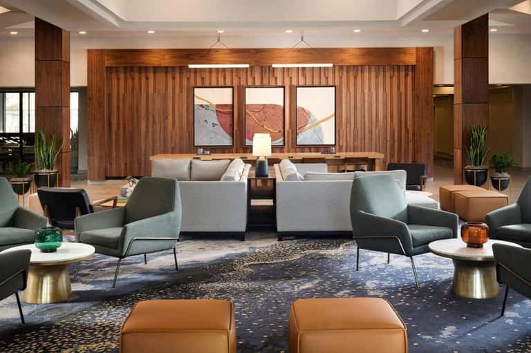 Spacious hotel lobby with wood paneling, seating areas, and contemporary art
