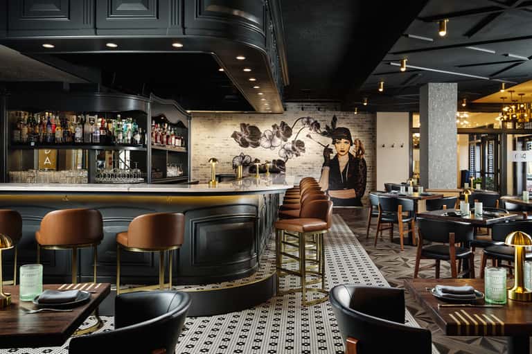Upscale bar and restaurant with dark modern design, copper accents, and elegant furnishings