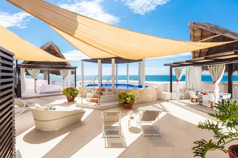 Luxury rooftop terrace with ocean view, cabanas, infinity pool, and sail shade coverings