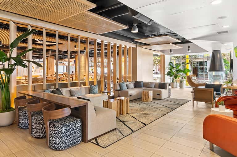 Contemporary resort lobby with wooden partitions, lounge seating, and natural light
