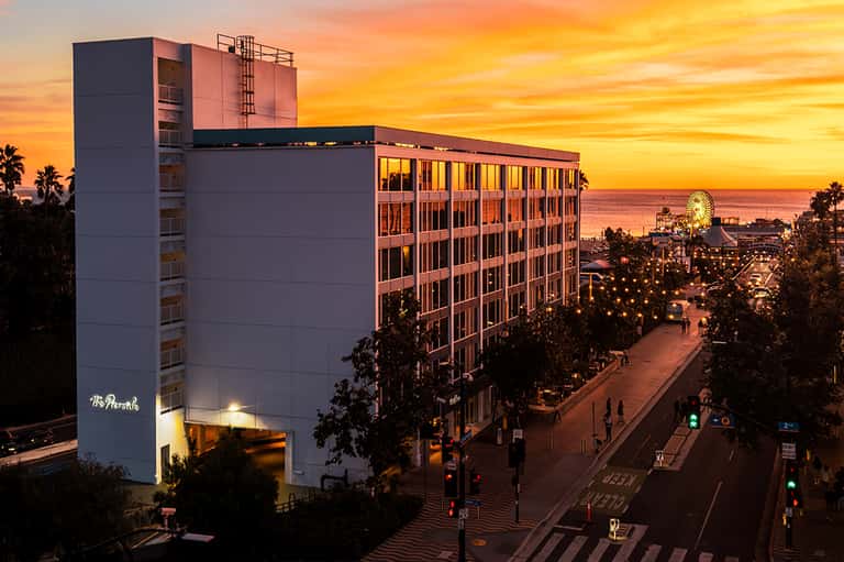 Hotel at sunset with illuminated Ferris wheel and oceanfront boardwalk