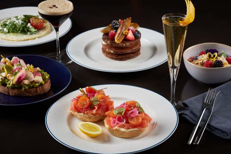 Fine dining plates featuring gourmet seafood, toast, and desserts with cocktails