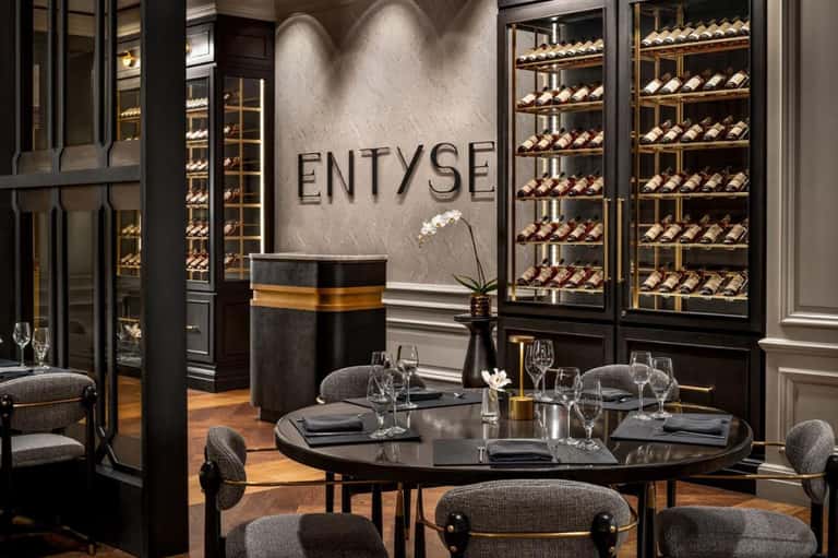 Fine dining restaurant entrance with wine display cases and elegant round dining table