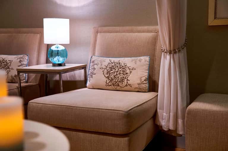 Elegant spa suite with upholstered headboard and soft ambient lighting
