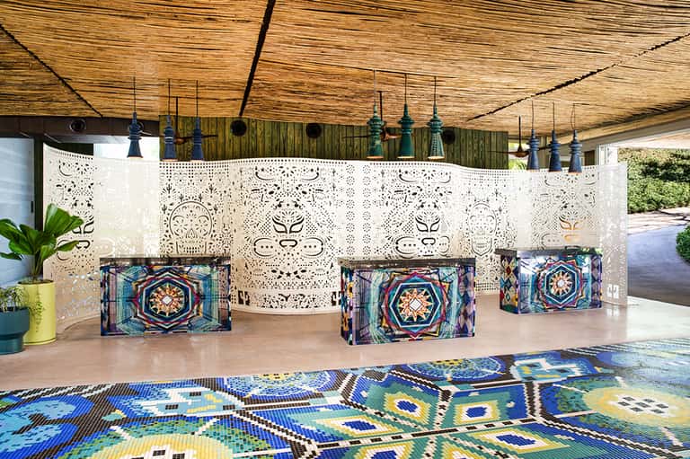 Resort entrance with decorative white lattice wall and colorful mosaic floor